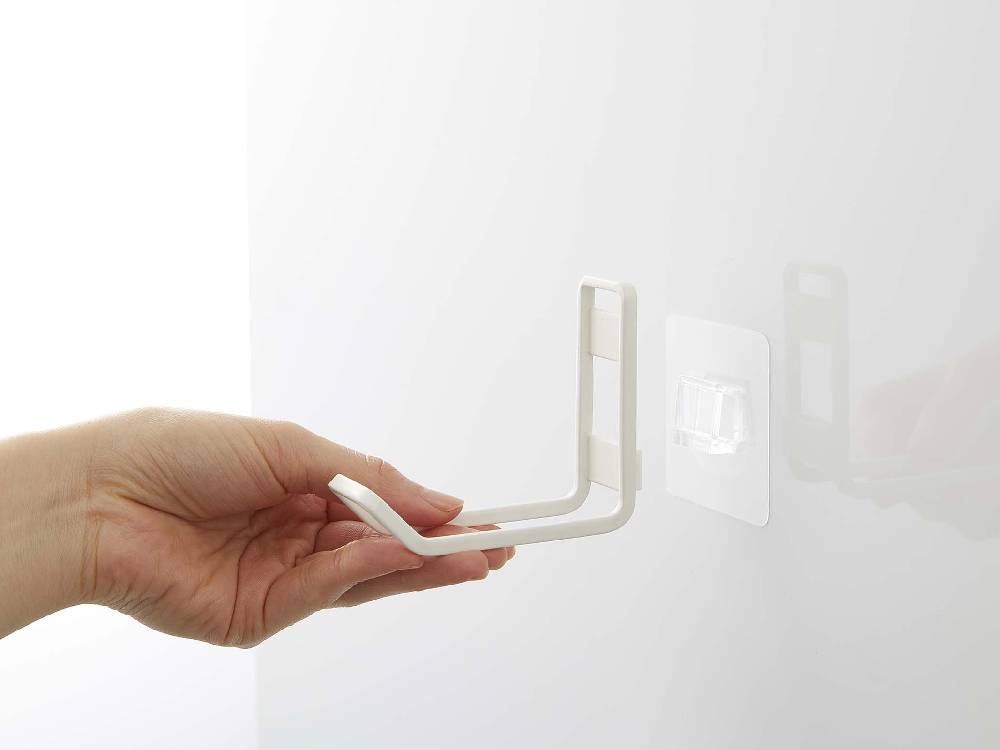 スチール製のタワー フィルムフックトイレ用品収納フックが光沢のある壁面に取り付けられている様子。耐荷重750gのポリカーボネート製フックが見えます。