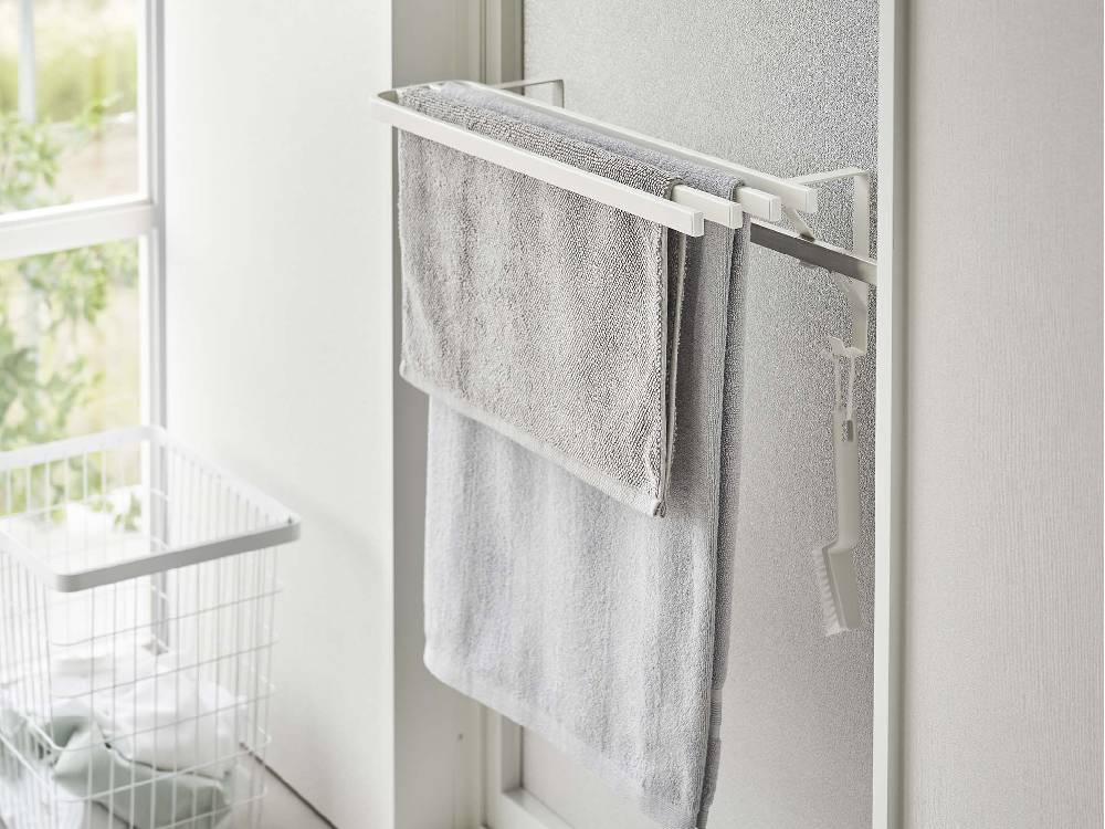 シルバーのタワー浴室扉タオル掛け上バスタオルハンガーが浴室の棚に取り付けられ、バスタオルが掛かっている様子