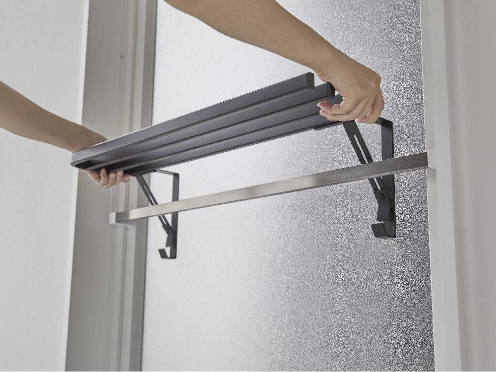 アルミ製のタワー型浴室扉タオル掛け上に設置された銀色のハンガーとシェルビング