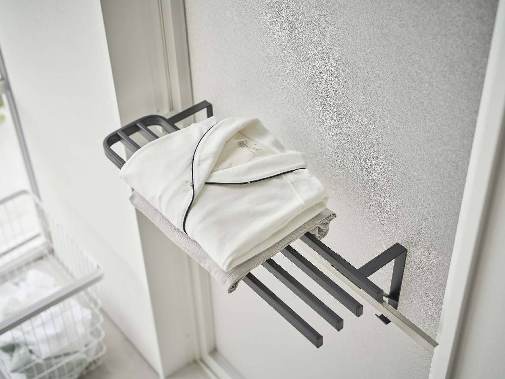 灰色の金属製バスタオルハンガーが浴室扉に取り付けられている様子