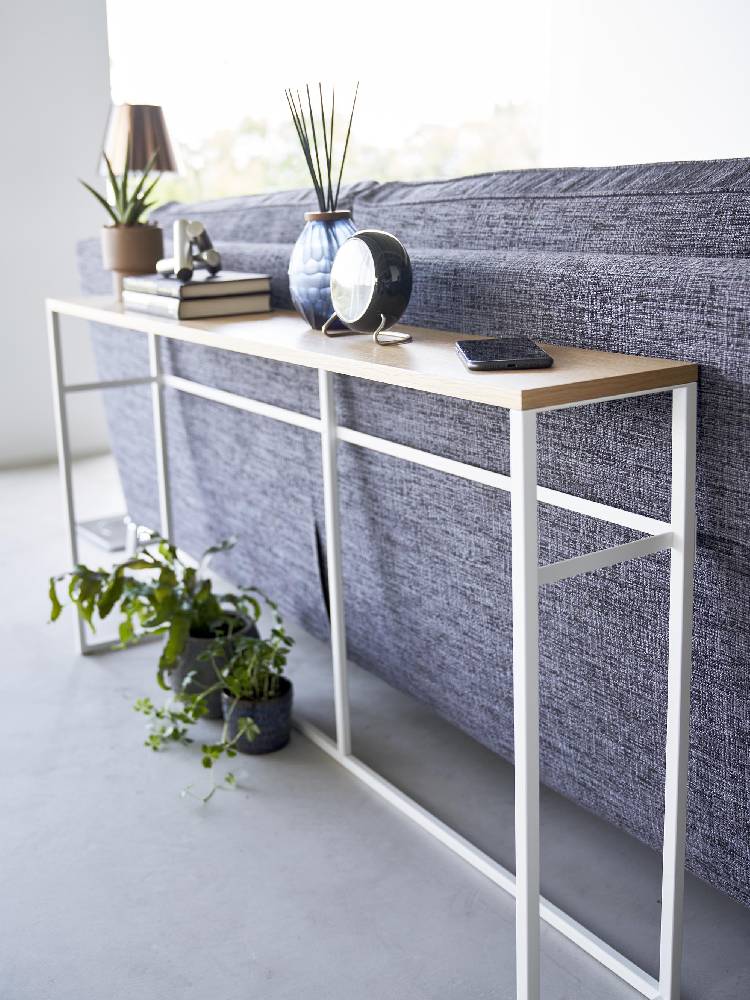 スチール製フレームと天然木天板を使用したタワーソファー裏コンソールテーブルが木製床の上に配置されています