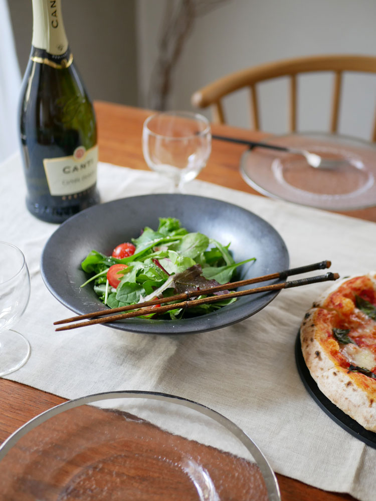 公長斎小菅の黒竹取り箸と食器がテーブルに並び、華やかなおもてなしの食卓を演出している様子