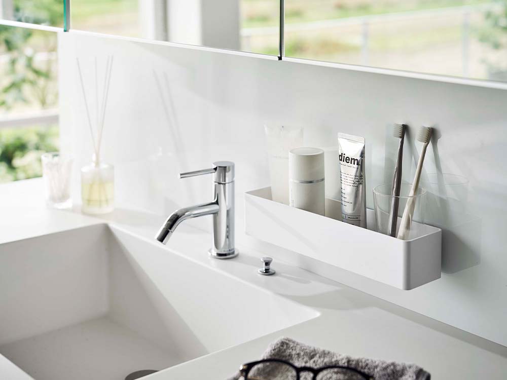 白色のフィルムフックラックが設置されたモダンな浴室の洗面台と蛇口