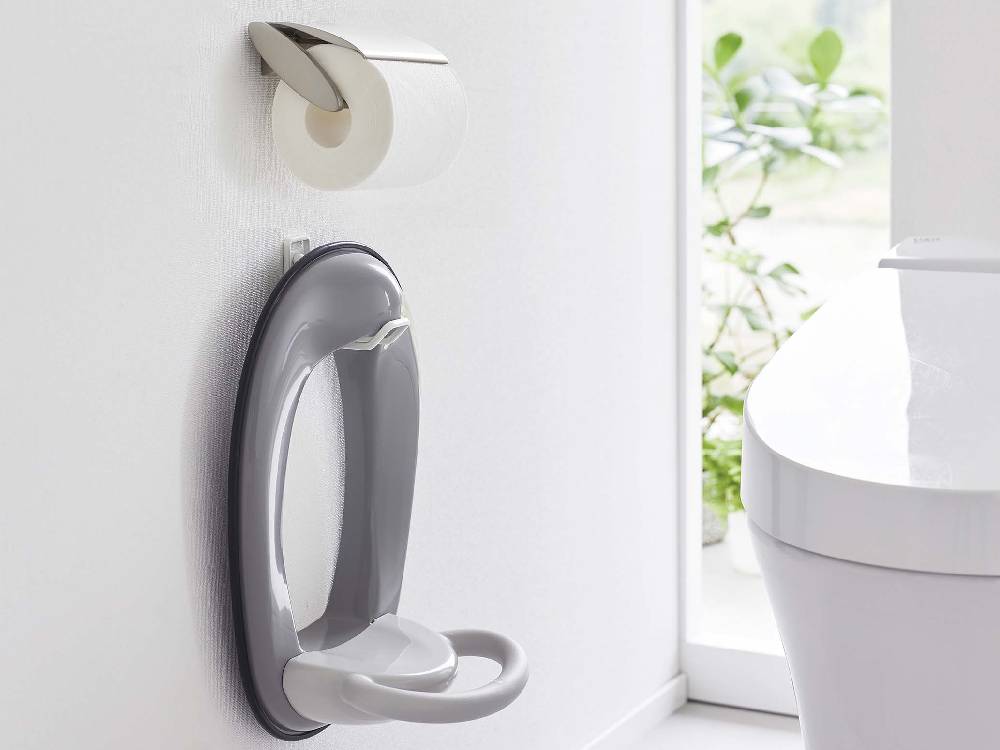 白いトイレにシルバーのタワー型ウォール収納フックが取り付けられているバスルームの様子