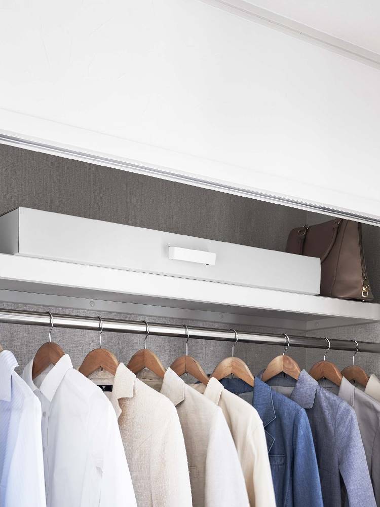 タワー式着物収納ボックスがクローゼット内の棚に置かれ、衣類ハンガーと共に整理されている様子