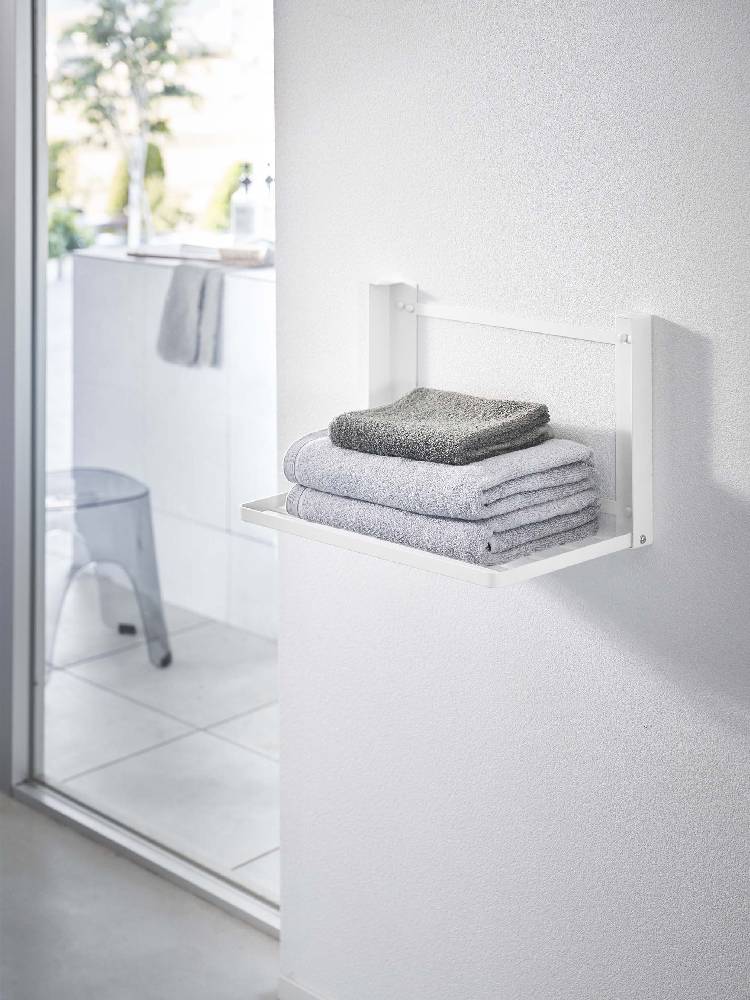 石こうボード壁に設置された【tower/タワー】折り畳み棚が備えられたバスルーム内部