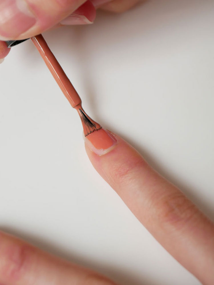 ピンク色のネイルポリッシュを塗った美しい手の写真