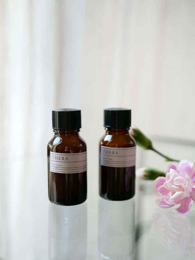 THERA/テラの爪に優しい大人用ネイルカラーが入ったプラスチックとガラスのボトルが、ラベルとキャップ付きで並んでいる