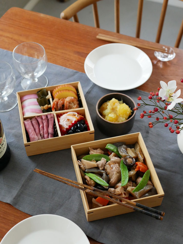 公長斎小菅の竹製二段重箱に盛り付けられた彩り豊かな料理と食器