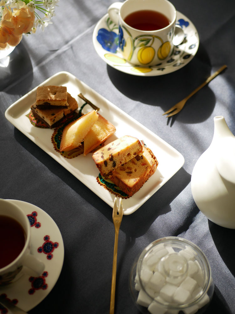 Iittala（イッタラ）のタイカ サトスクエアプレートにケーキやカップが美しく配置された食卓のシーン。