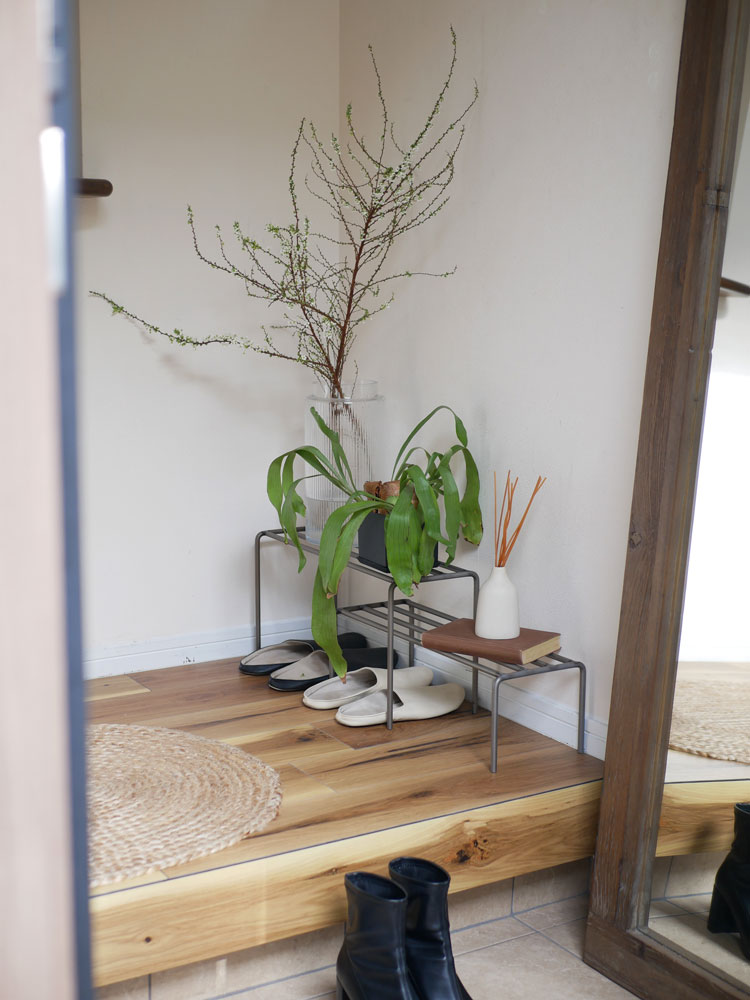 アイアン製のウエストビレッジトーキョーKNOPプラントスタンドに置かれた鉢植え。木材の花瓶やプランツステムが自然素材のフロア上に配置されています。