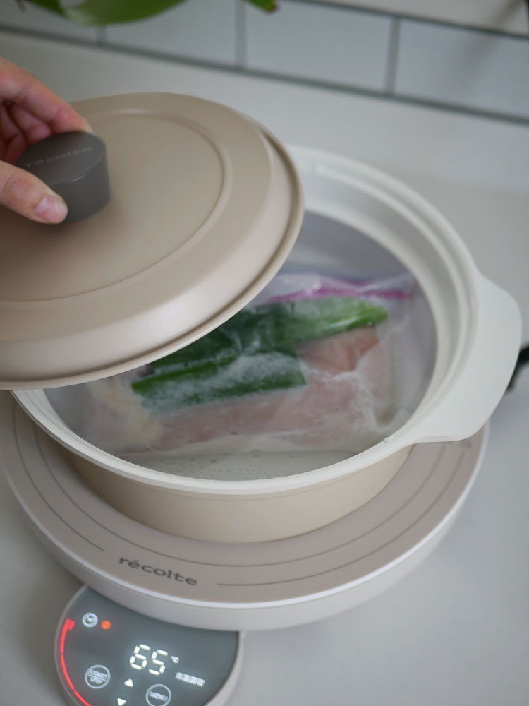 レコルトの卓上IHクッキンググリドルがキッチン上に置かれ、野菜や調理器具とともに使用されている様子