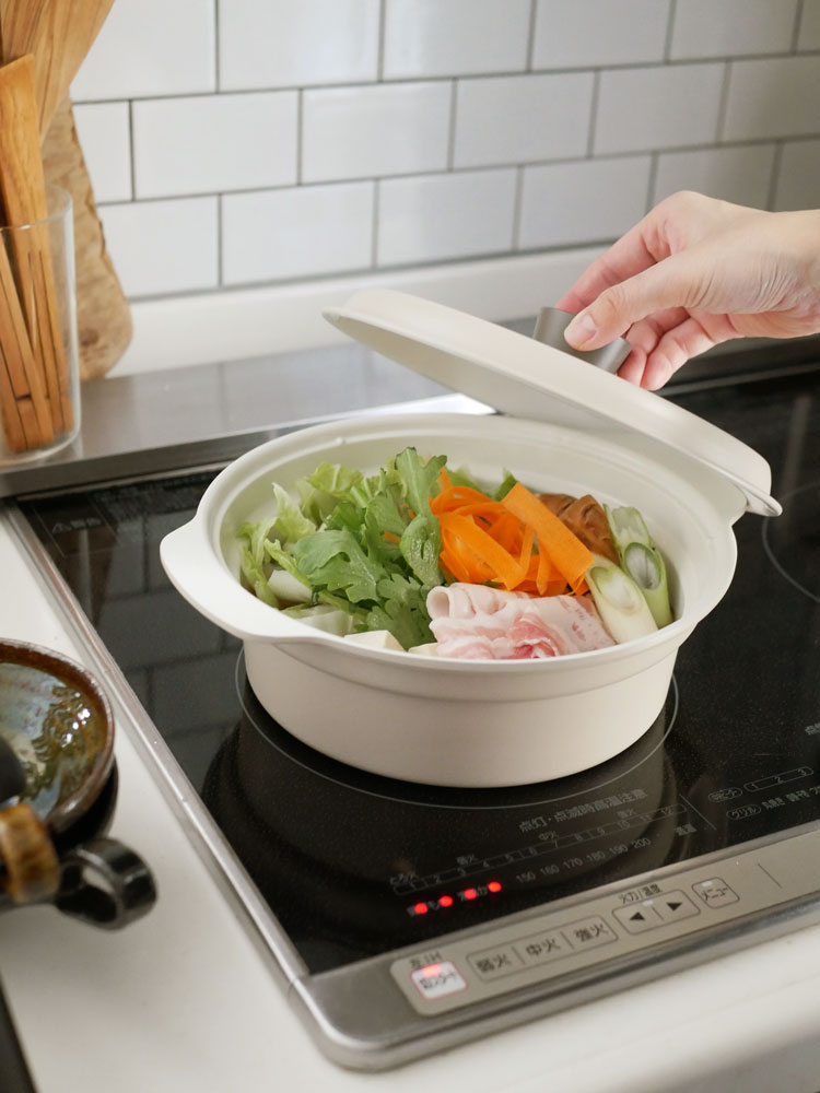 レコルト卓上IHクッキンググリドルで調理中の食材と食器がテーブルに並んでいるキッチンの様子