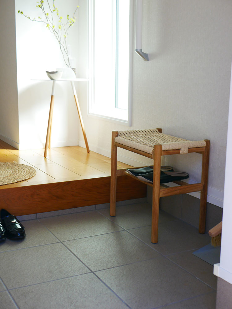 チーク無垢材とペーパーコードで作られたサンフラワーラタンのHOKOSペーパーコード×チークスツールが木製フローリングの上に置かれている様子