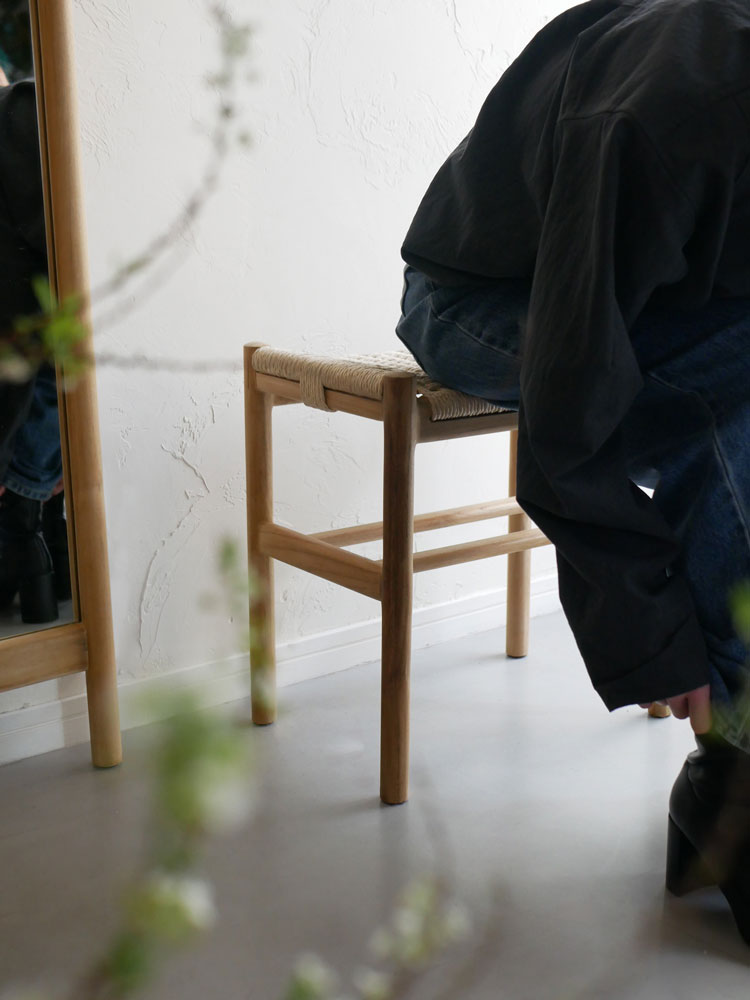 サンフラワーラタンとチーク材を使用したHOKOSペーパーコード×チークスツールが木製フローリングの上に置かれたスタイリッシュな椅子