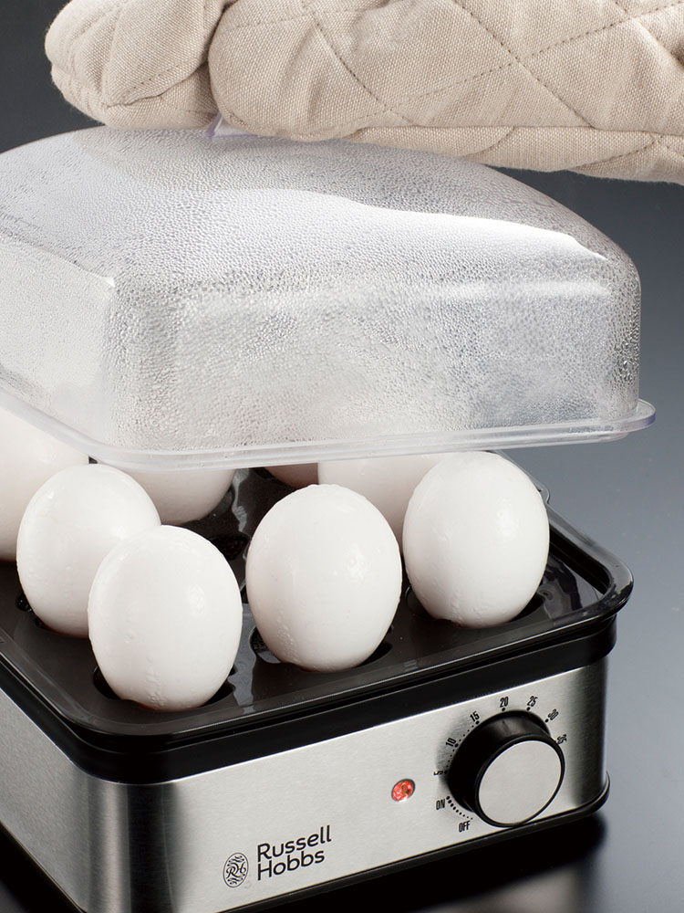 Russell Hobbsのミニスチーマーに食材がセットされ、スープトレイやスチーム皿などの付属品が並べられている調理風景