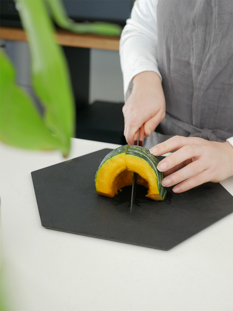 協和工業のスーパーストーンバリア包丁と専用シャープナーがカッティングボード上に新鮮な野菜とともに配置されたキッチン用品の画像