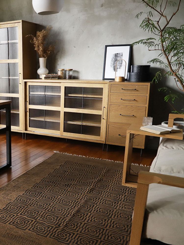 木製フローリング上に配置されたアデペシュ マニエール コットンラグとインテリア家具の室内画像