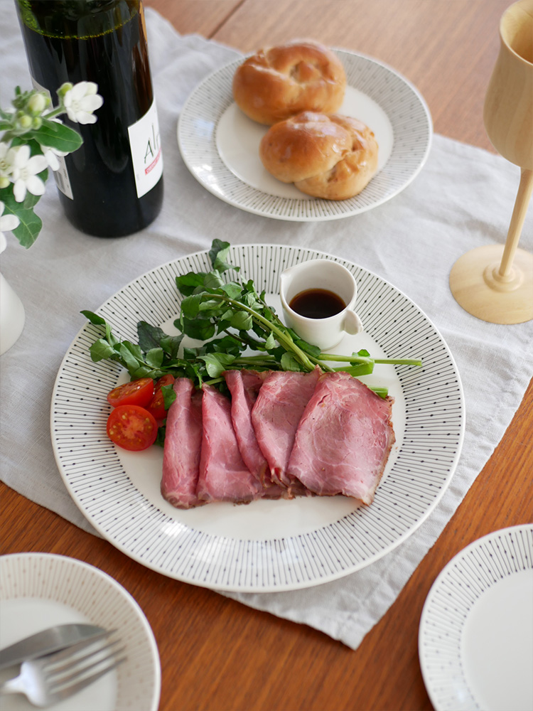 アラビアのマイニオ磁器プレートに盛られた料理がテーブル上に配置された様子