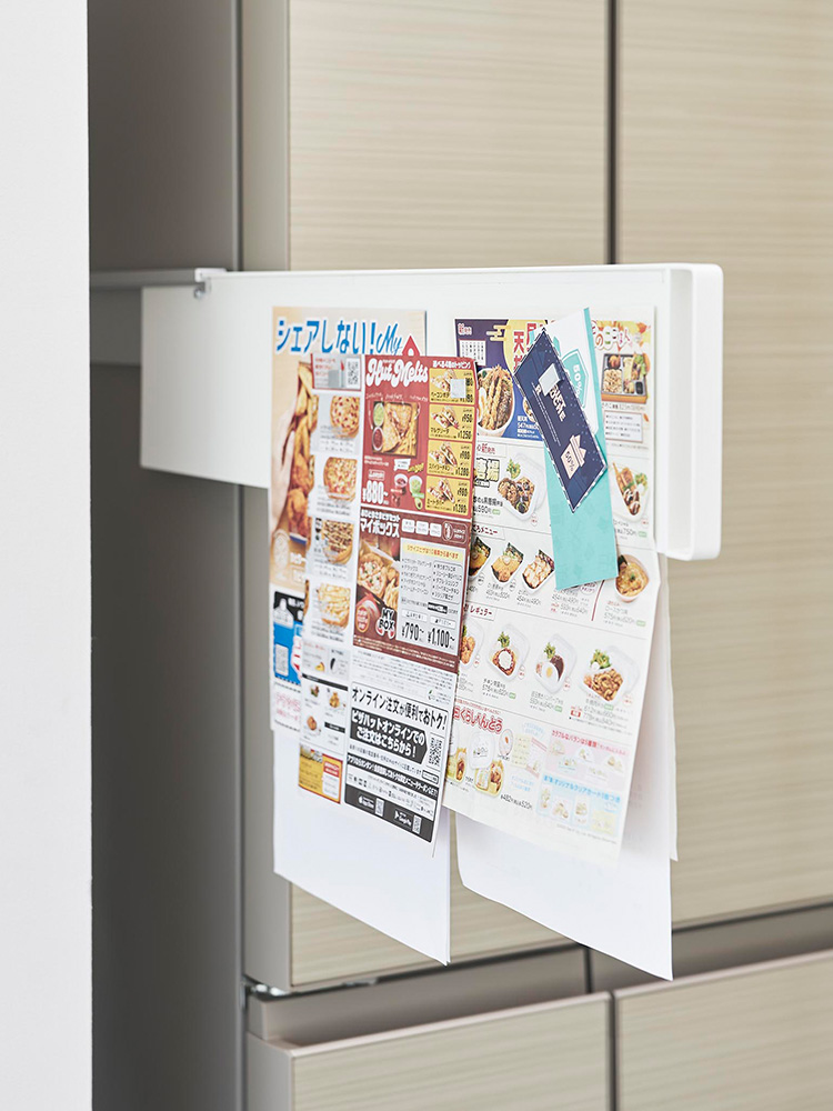 冷蔵庫横にマグネットで取り付けられたスライド式スチールパネル。オフィス用品やボックスを整理収納できる棚が配置されています。