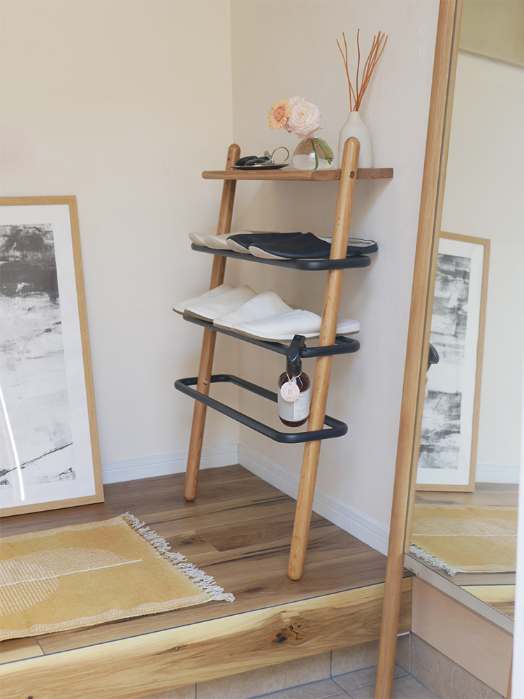 オーク無垢材とスチールで作られた立て掛け式シューズラック。複数の木製棚がナチュラルな仕上げで配置されています。