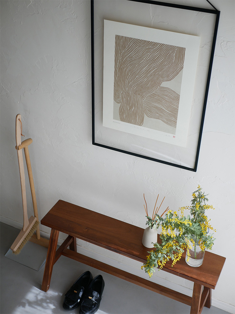 木製家具が並ぶ木床の室内に飾られたハインスタジオのデンマーク製アートポスターと鉢植え。