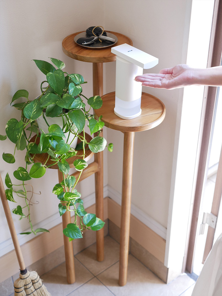 ハードウッドのテーブルにゼラニウム入りの花瓶と【±０】オートディスペンサーが並べられている様子