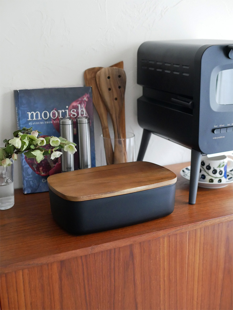 レコルト製のクリームホワイトまたはブラックのABS樹脂とアカシア木材を使用したブレッドケース。キッチンでパンを美しく収納するホームアプライアンス