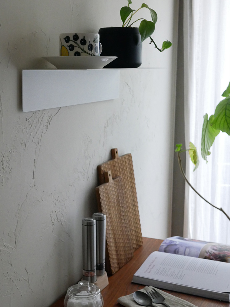 マグネットが付いたウォールラックにセラミックの花鉢と観葉植物が飾られている様子