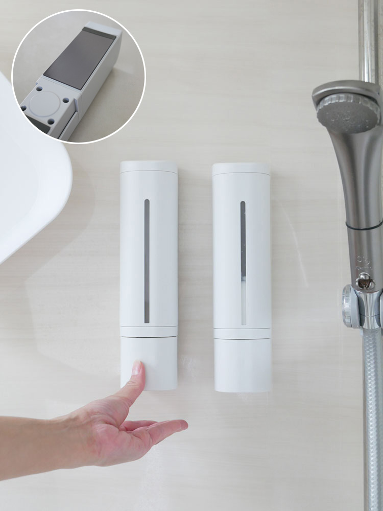 リッチェルの下から出るマグネットディスペンサーがバスルームの洗面台に取り付けられており、ソープディスペンサーやハンドドライヤーとともに配置されている様子