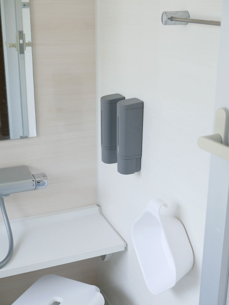 リッチェルの銀色マグネットディスペンサーが浴室のシンクに取り付けられている様子