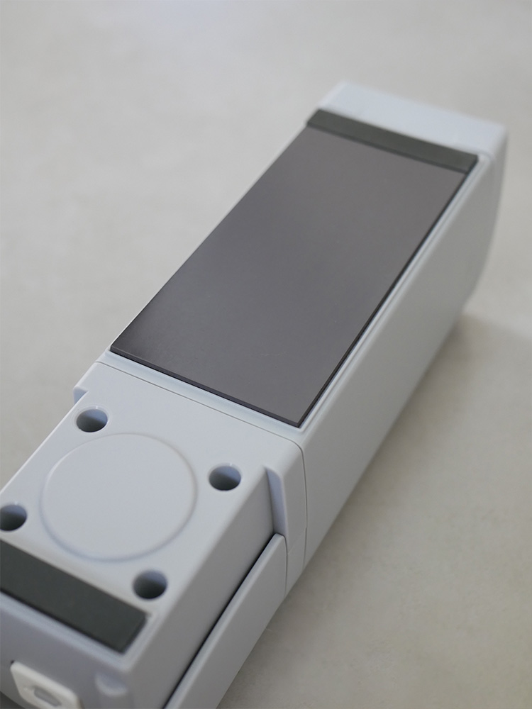 白色のリッチェル下から出るマグネットディスペンサーが平らな壁面に取り付けられている様子