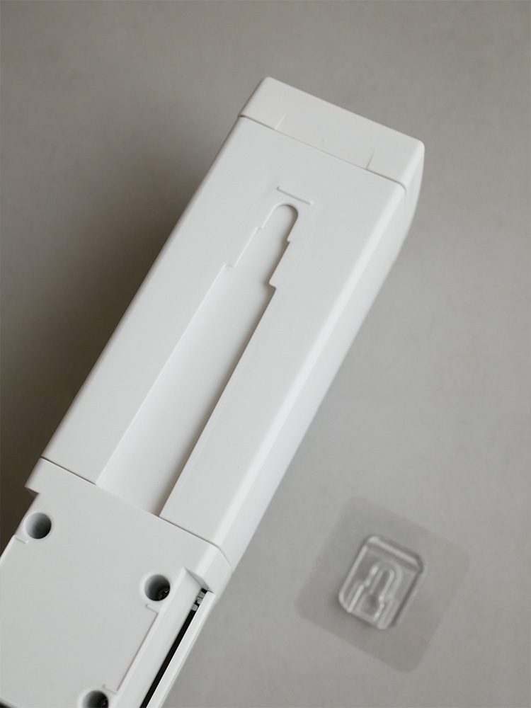 リッチェル製下から出るシールフックディスペンサーの白色モデルが、光沢のあるキッチンの壁に取り付けられている様子