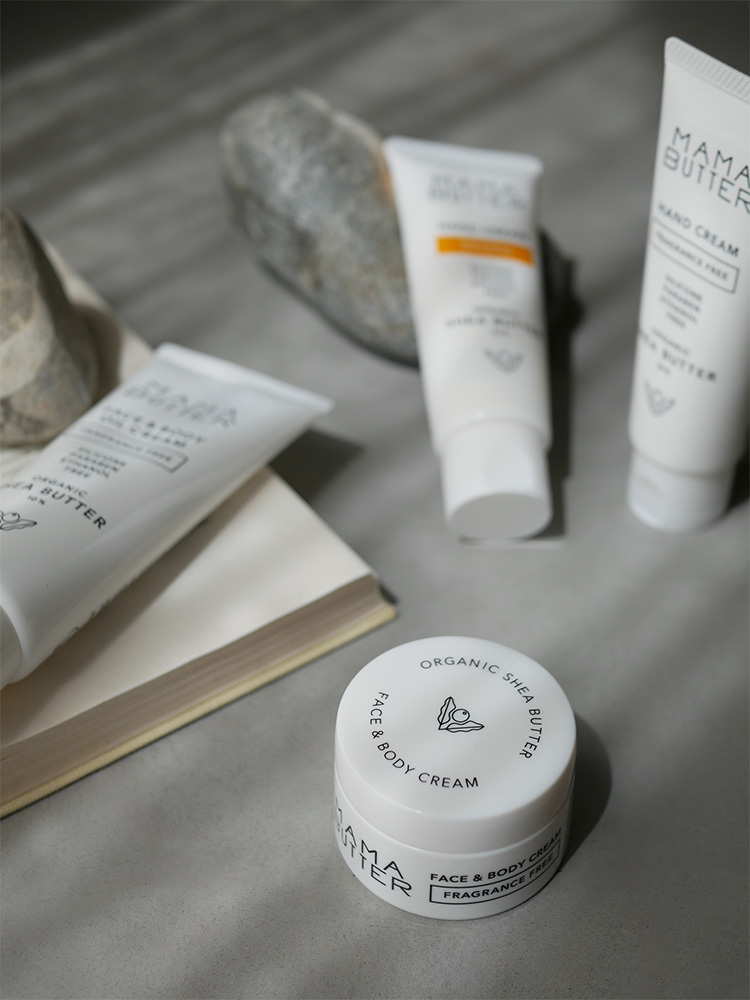ママバターの無香料フェイス、ボディ、ハンドクリームがシンプルで上品なデザインのパッケージに並べられている様子