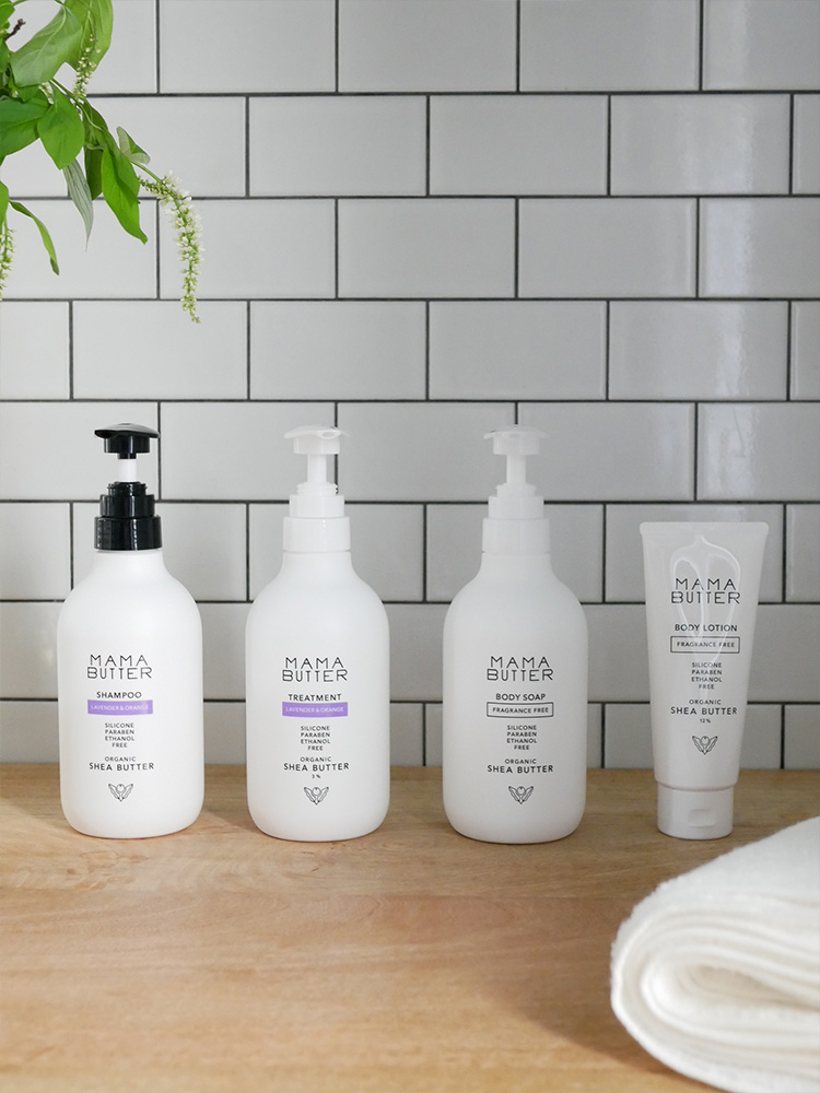 ママバターのシャンプー、トリートメント、ボディソープ、ボディローションがラベル付きボトルに入れられ、棚に整然と並べられている