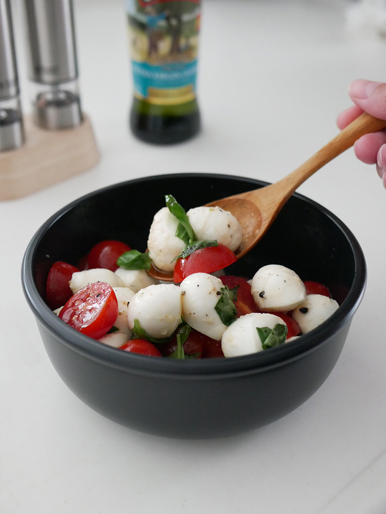 ボウルに盛られたチェリートマトと他の野菜がテーブル上に置かれている様子