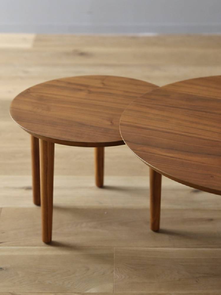 高野木工のBALLOONシリーズ伸縮自在なリビングテーブル。ブラウンのハードウッド製で、花束が飾られたコーヒーテーブル。