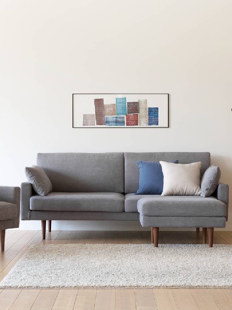 高野木工LEOソファが配置されたリビングルーム、コーヒーテーブルや観葉植物、ランプが調和する快適な空間