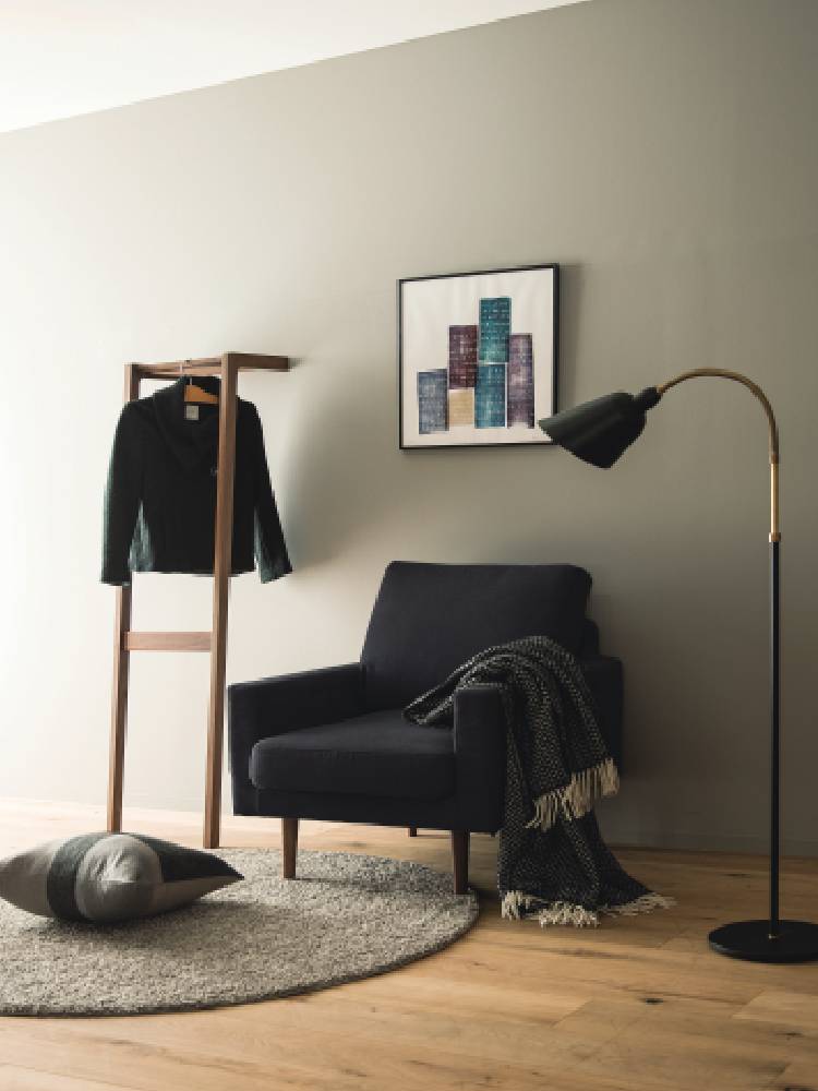 茶色と黒の高野木工LEOソファが配置されたグレーの床を持つモダンなリビングルームのインテリア