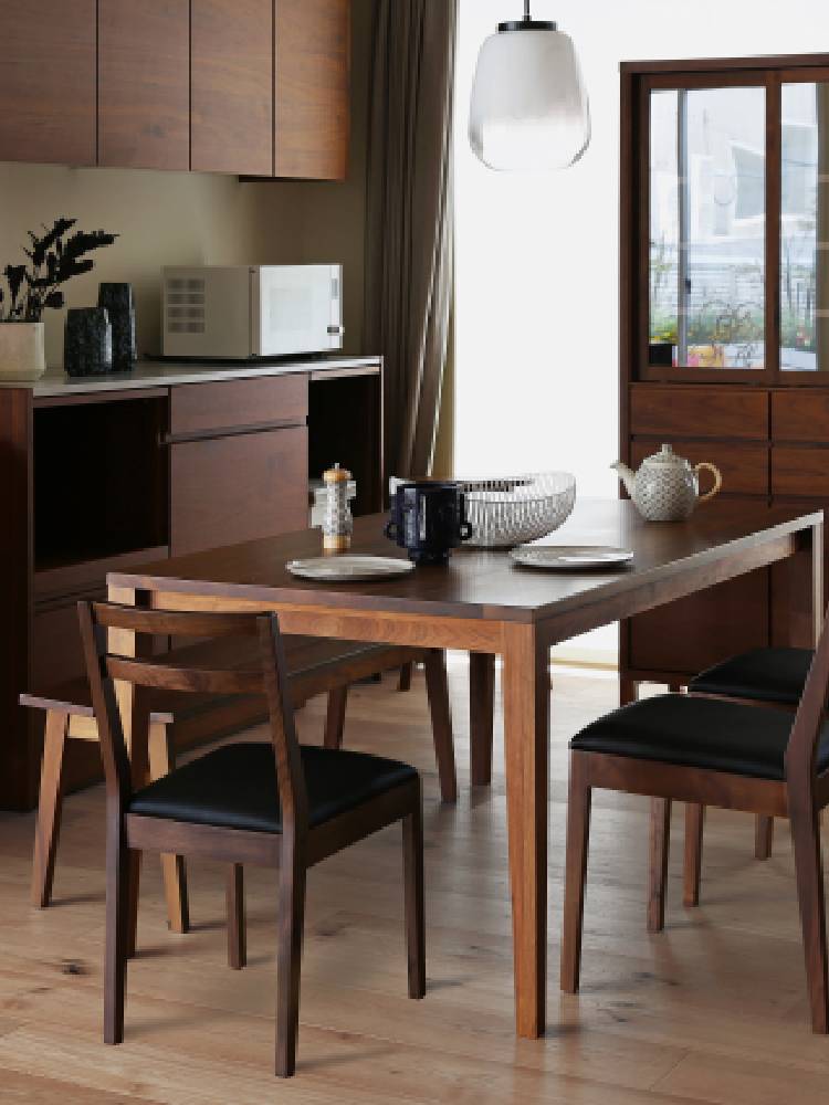 高野木工製のホワイトオークおよびウォルナットのPLAIN CHAIR VIETNAMダイニングチェアが木製テーブルと共にモダンなダイニングルームに配置されている様子