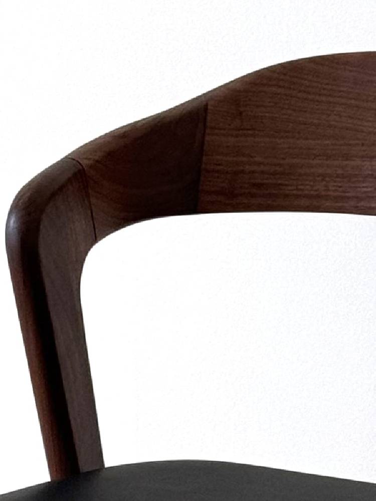 高野木工のSWELLダイニングチェア、ブラウンのウレタン塗装が施されたウォルナット無垢材フレームとPVC生地の椅子