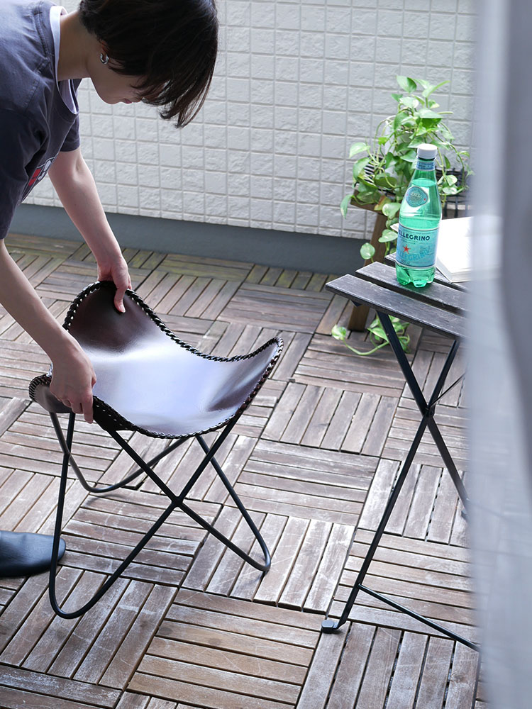 インド産の牛革とアイアンで作られた【WRAPS/ラップス】アイアンレザースツールが木製の床の上に置かれている様子