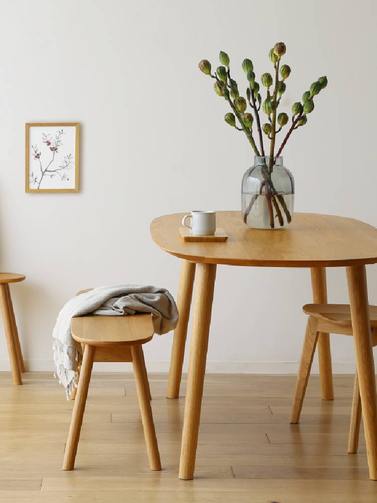 高野木工のRUBEダイニングテーブルと花鉢が配置されたスタイリッシュなダイニング空間