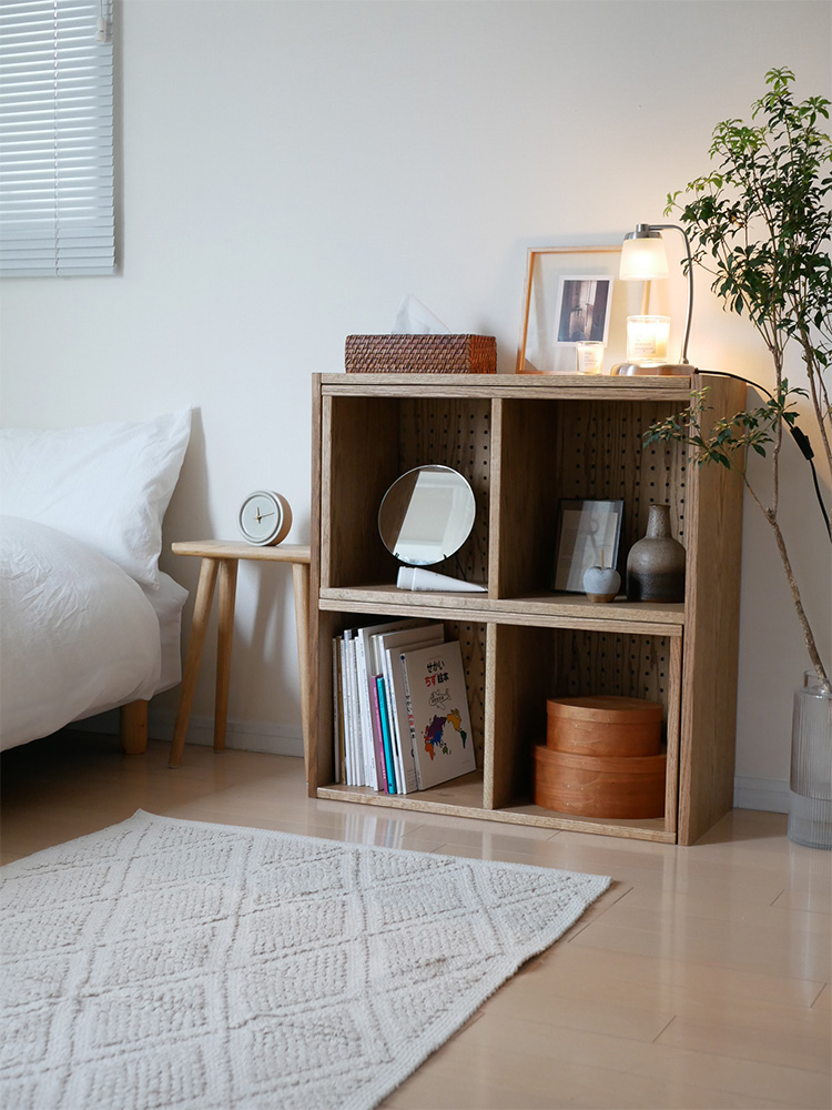 赤オークの天然木を使用した【nora/ノラ】伸ばせて曲がるオープンシェルフが、リビングルームの床に配置されている様子