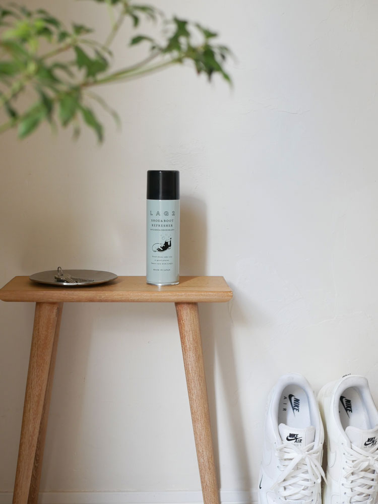 木材を使用した家具とスツール、花鉢が配置されたナチュラルな室内空間。