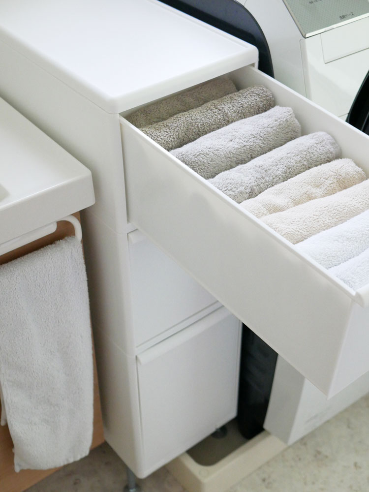 ホワイトのアジャスター付きスリムストッカーと引き出しが備えられたバスルームキャビネット