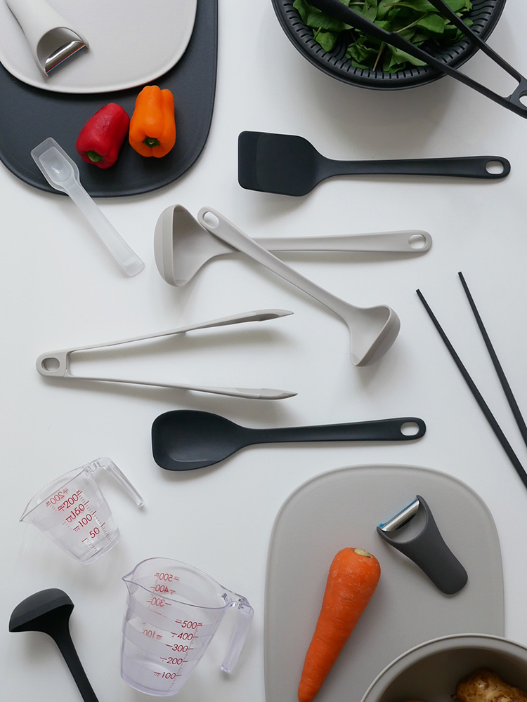 マーナの基本計量スプーンがキッチンのテーブル上に置かれている様子。プラスチック製でハンドル付きの調理用スプーン