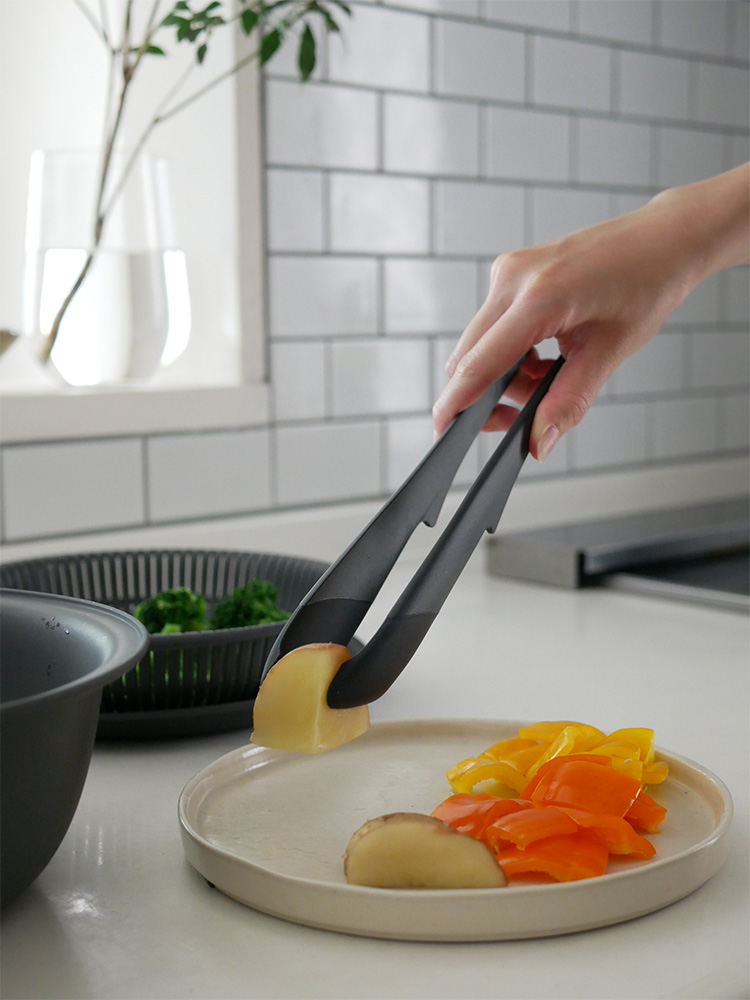 マーナのきほんトングとスプーン、スパチュラが調理中の食材と共にキッチンに並べられている