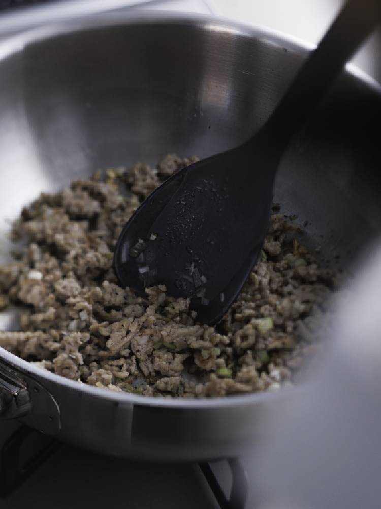 ナイロンとシリコーンゴム製のマーナのきほんスプーンヘラがフライパンと一緒に調理台上で炒め物をしている様子