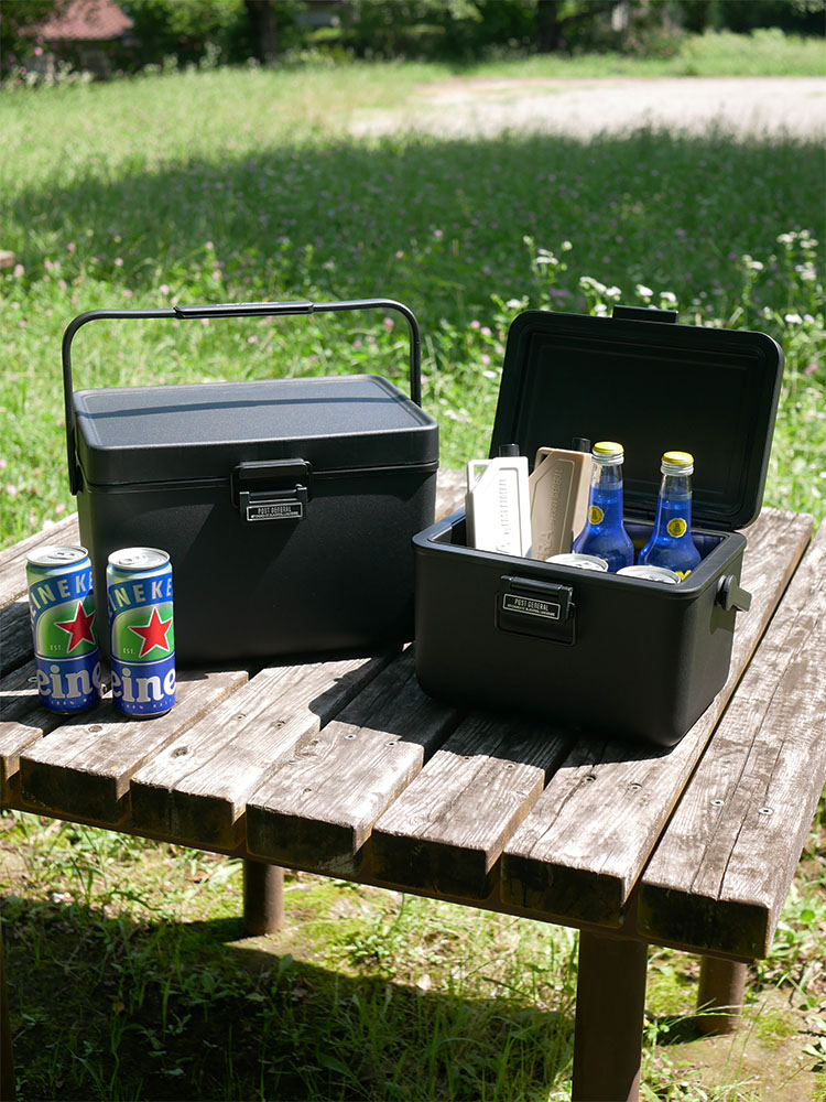 湖畔に配置されたTHE ICE ERAハードシェルクーラー、プラスチックボトル、バゲージの写真